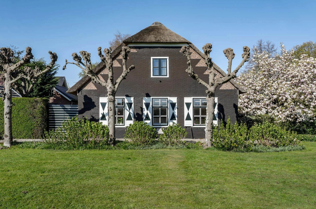 Voorgevel van een traditionele woonboerderij met luiken