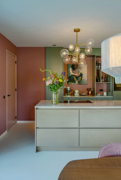 Vooraanzicht van een mintgroene keuken en roze wandbekleding