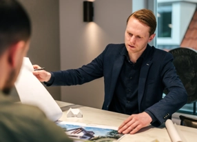 Architect bladert in brocure en is in gesprek met klanten