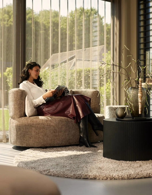 Vrouw zit in stoel in luxe woonkamer